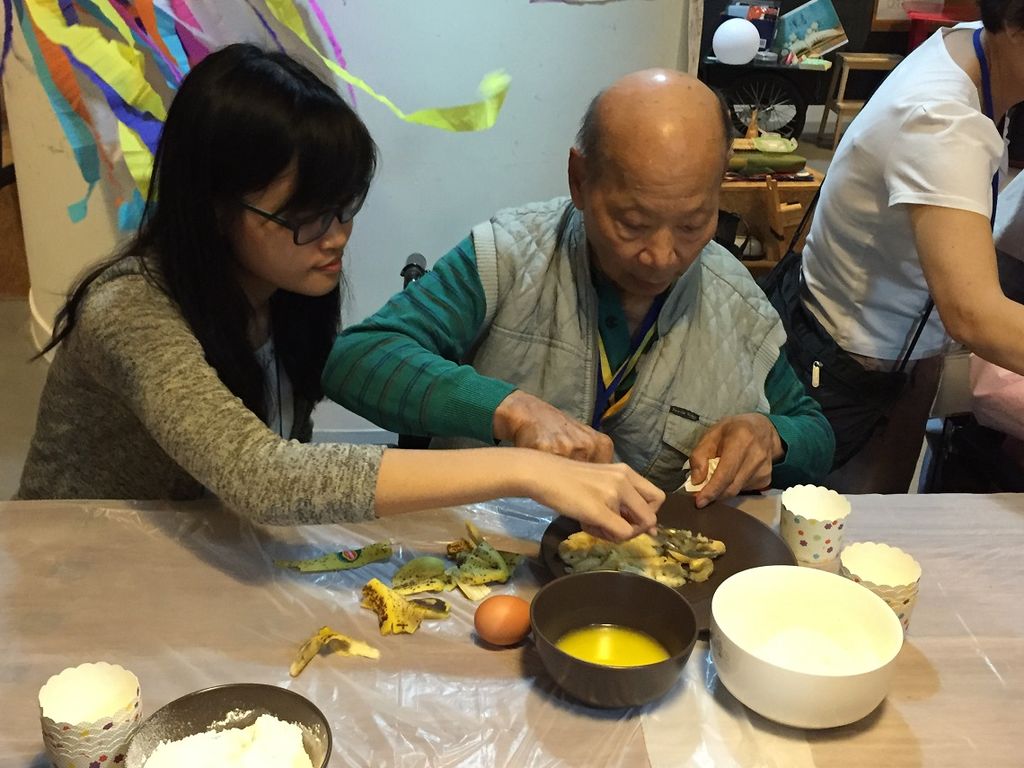 Student assisting the elder person in baking of banana muffins
